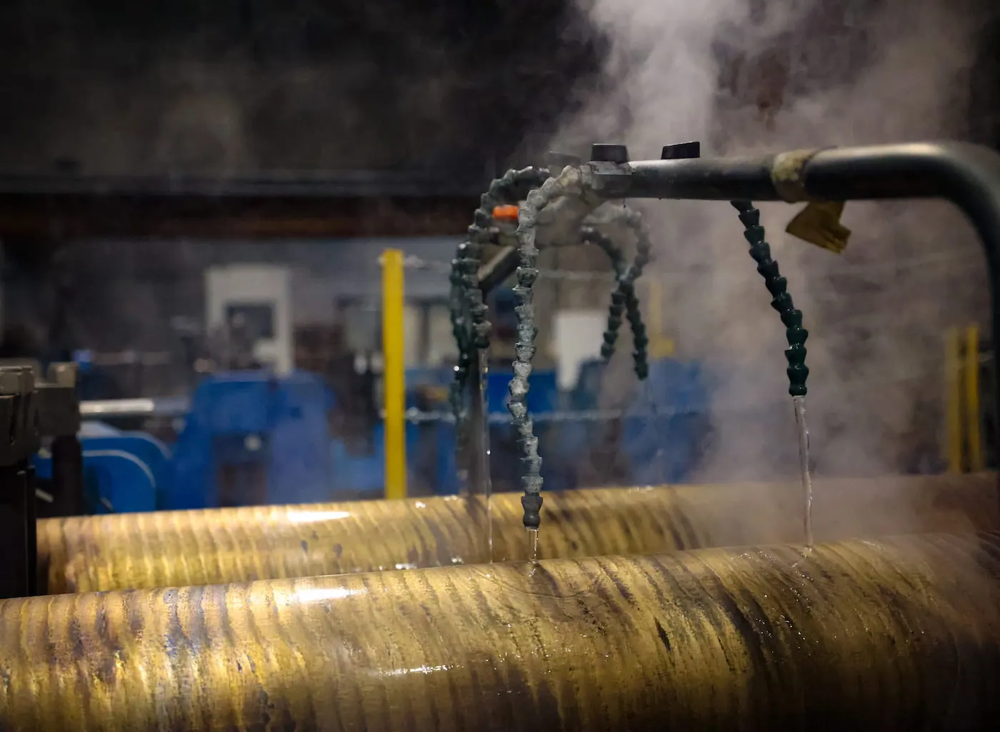 Wasserstrahlen und Dampf kühlen die Bronzestangen auf der Stranggusslinie